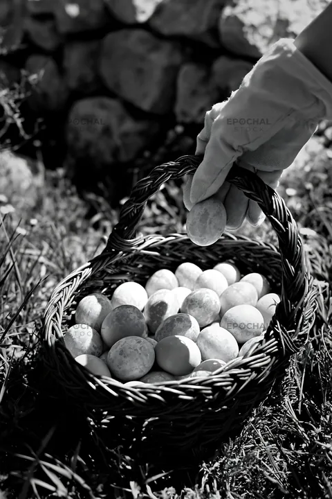 Easter basket filled with eggs in a meadow - AI-generated stock image