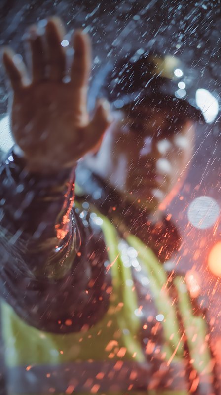 Police officer waves hand in rain at night Free Premium Stock Image - stock photo