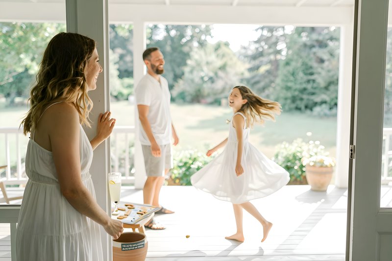 Family enjoys playful moments on a sunny porch in summer Free Premium Stock Photo - stock photo