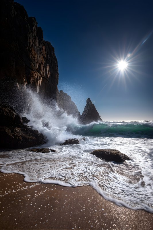 Waves crash on rocks under bright sun at the beach Free Premium Stock Photo - stock photo