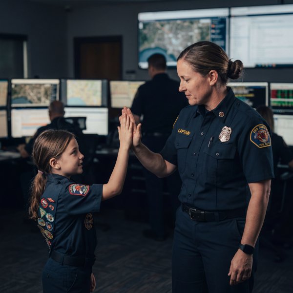 Young volunteer interacts with fire captain in control room - stock photo