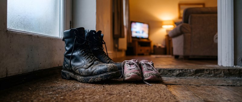 Boots and shoes placed by the door in a home setting Premium Stock Photo - stock photo