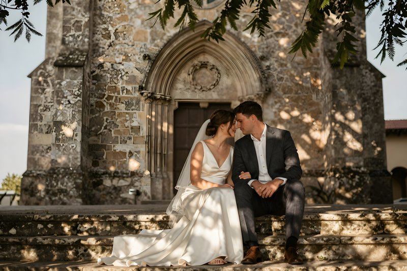 Couple sits together on steps outside old church Premium Stock Photo - stock photo