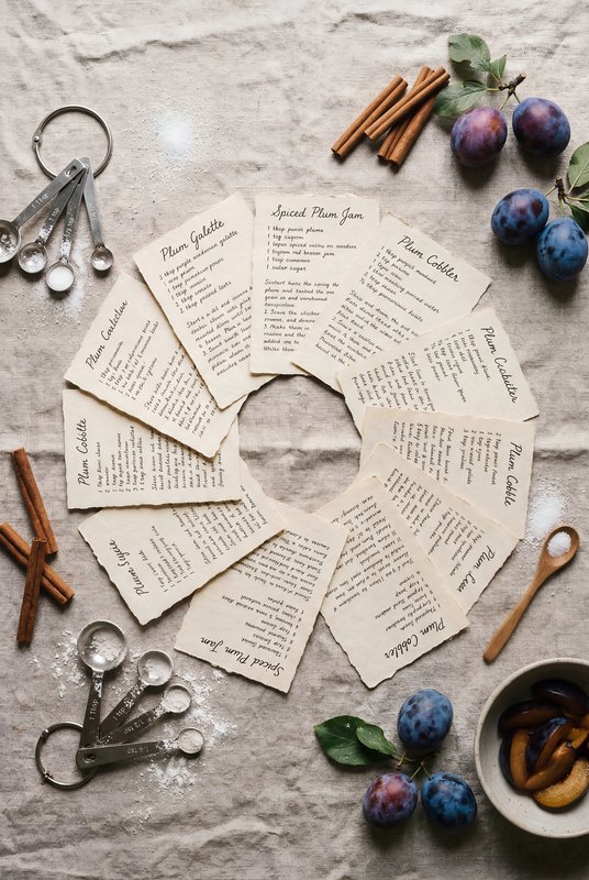 Recipes for sweet dishes with plums and spices on a table Premium Stock Image - stock photo