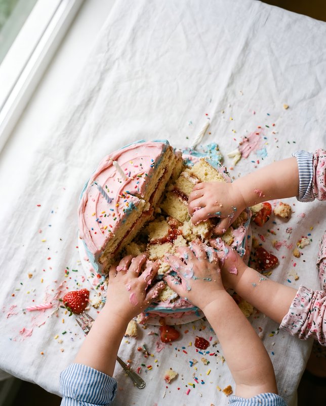 Children enjoy cake at a birthday party on a table Premium Stock Image - stock photo