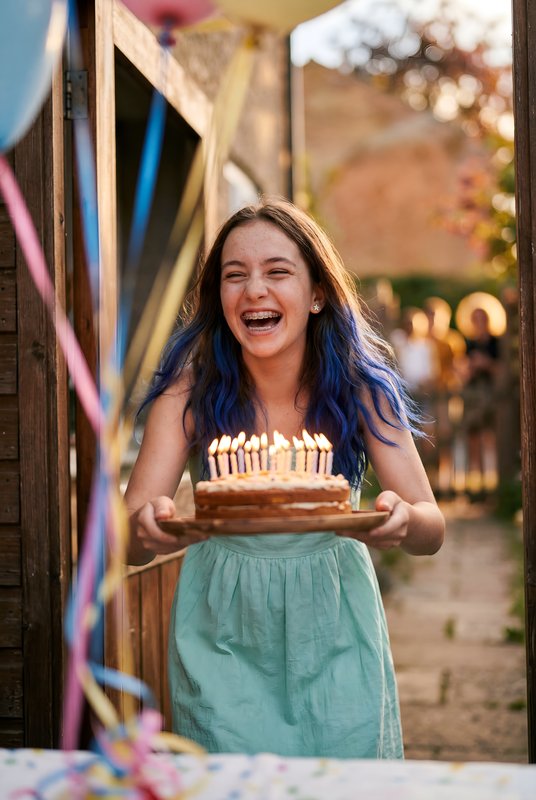 Girl celebrates birthday with cake and candles at a party Premium Stock Photo - stock photo