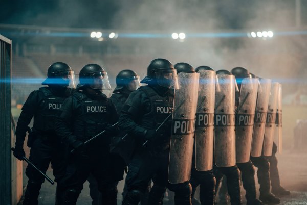 Police stand in formation during an event at night in a city - stock photo
