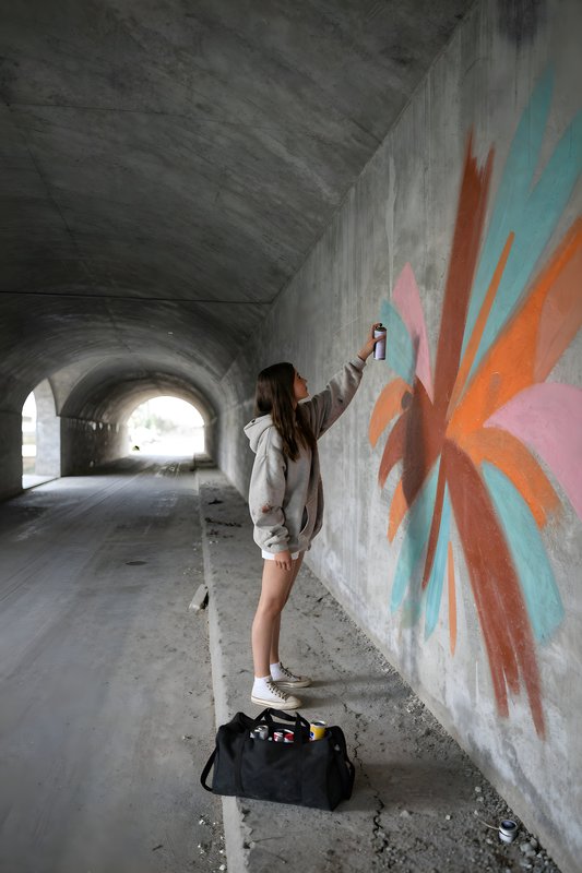 Spray painting bright design in tunnel during the day Premium Stock Image - stock photo