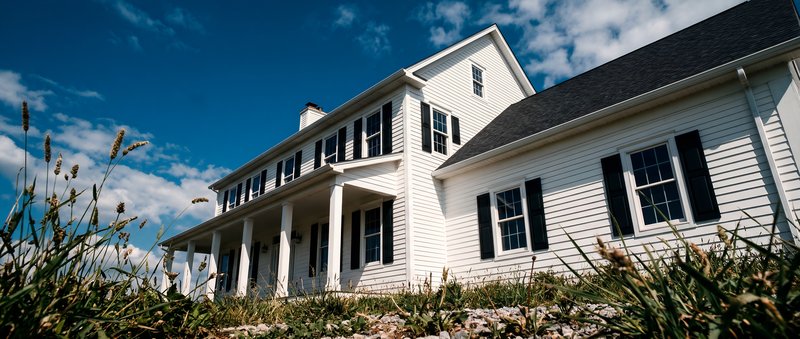 White house stands tall under blue sky with clouds Premium Stock Image - stock photo