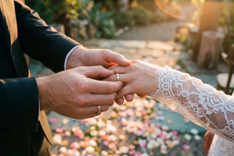 Couple exchanging wedding rings outdoors during sunset Premium Stock Image - stock photo