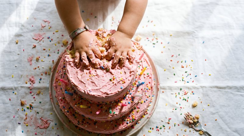 Child playing with a birthday cake at home during a party Premium Stock Image - stock photo