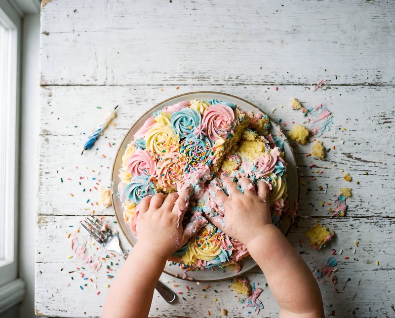 Child plays with cake on a table at a birthday party Premium Stock Photo - stock photo