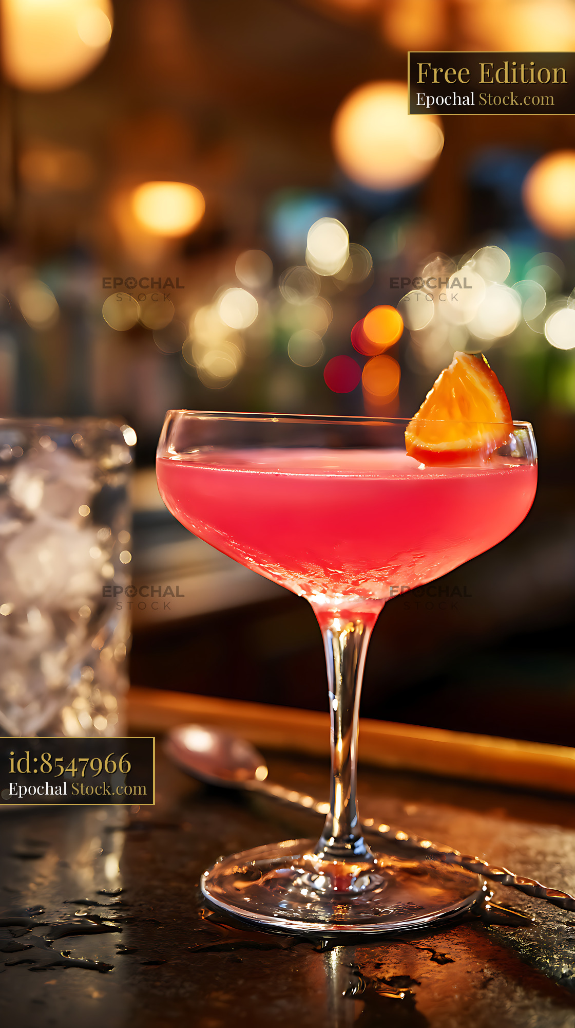Red Cocktail with Orange Garnish at Bar - stock photo