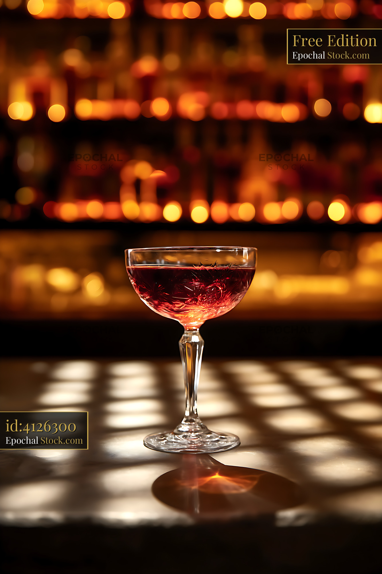 Elegant Red Cocktail in Coupe Glass on Bar Counter - stock photo