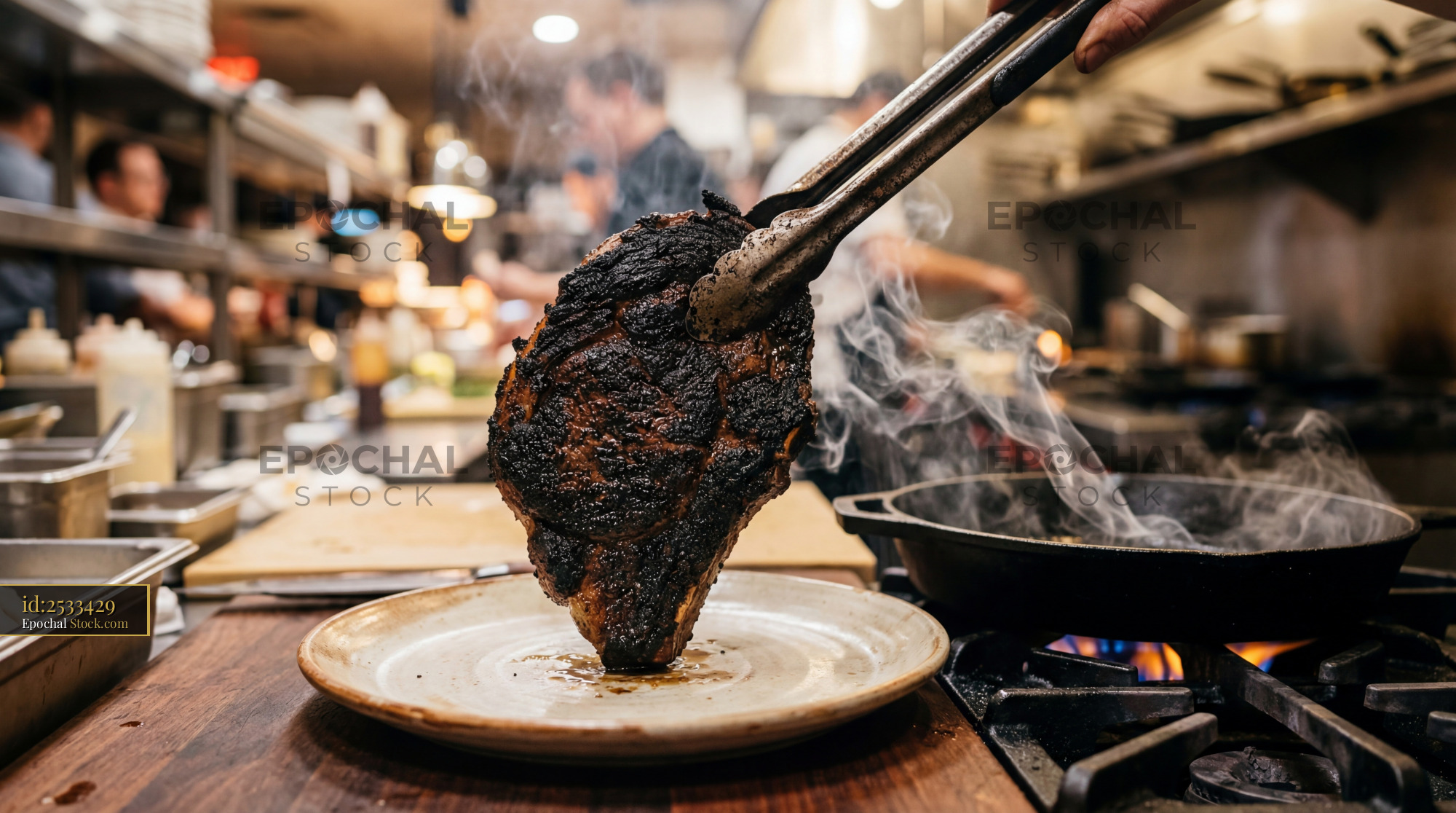 Chef Plating Charred Steak in Open Kitchen - stock photo
