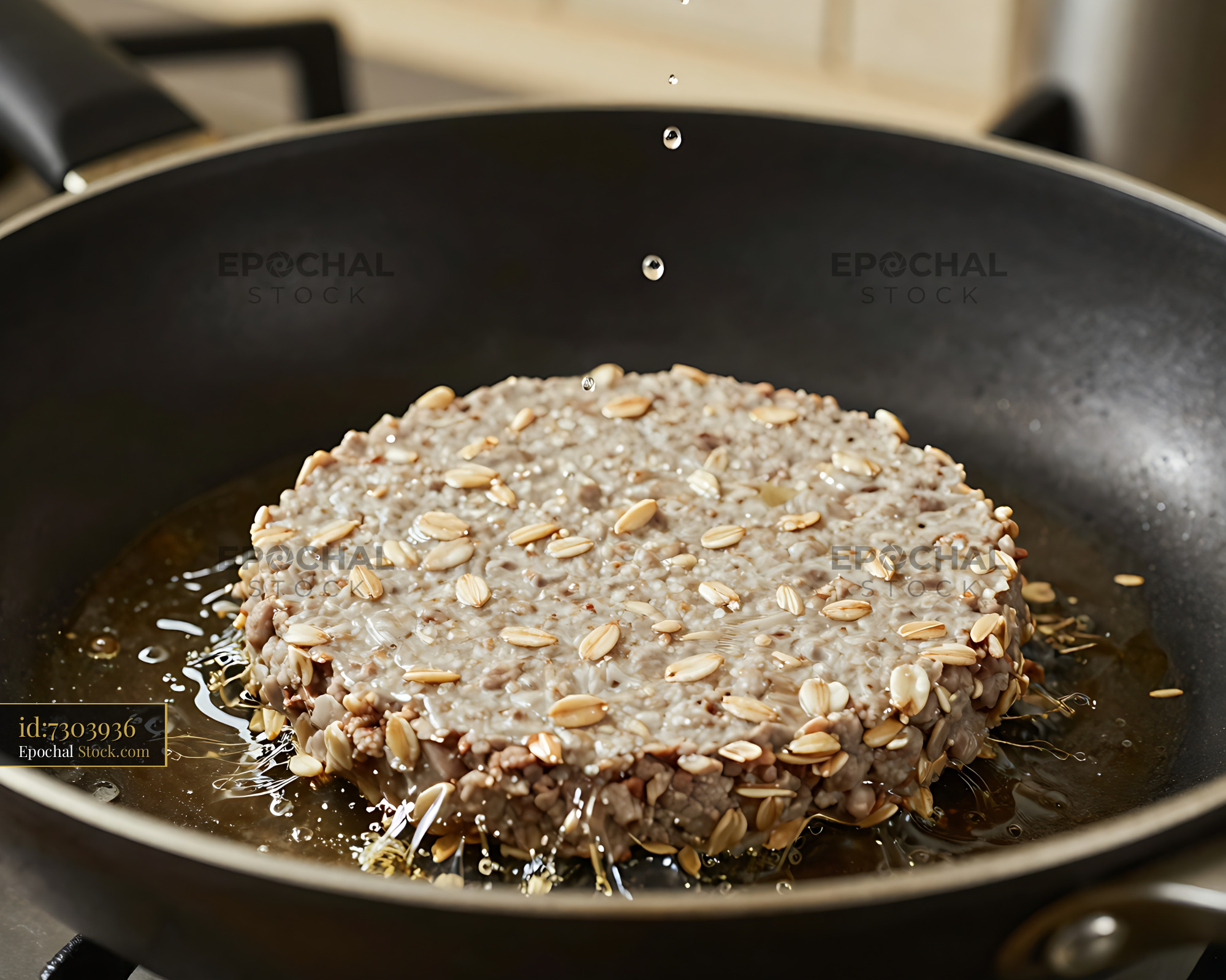 Oat-Topped Patty Sizzling in Hot Pan - stock photo