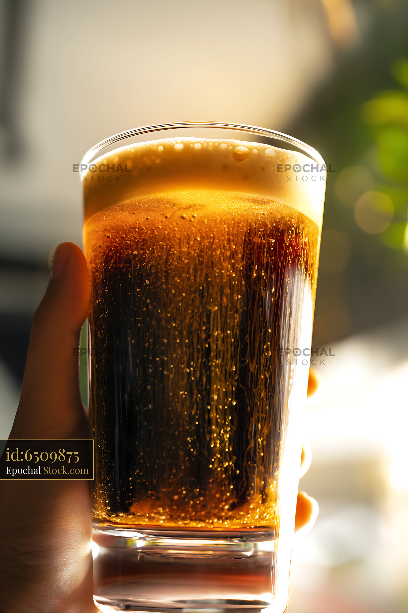 Nitro Caramel Coffee Held in Hand Outdoors - stock photo