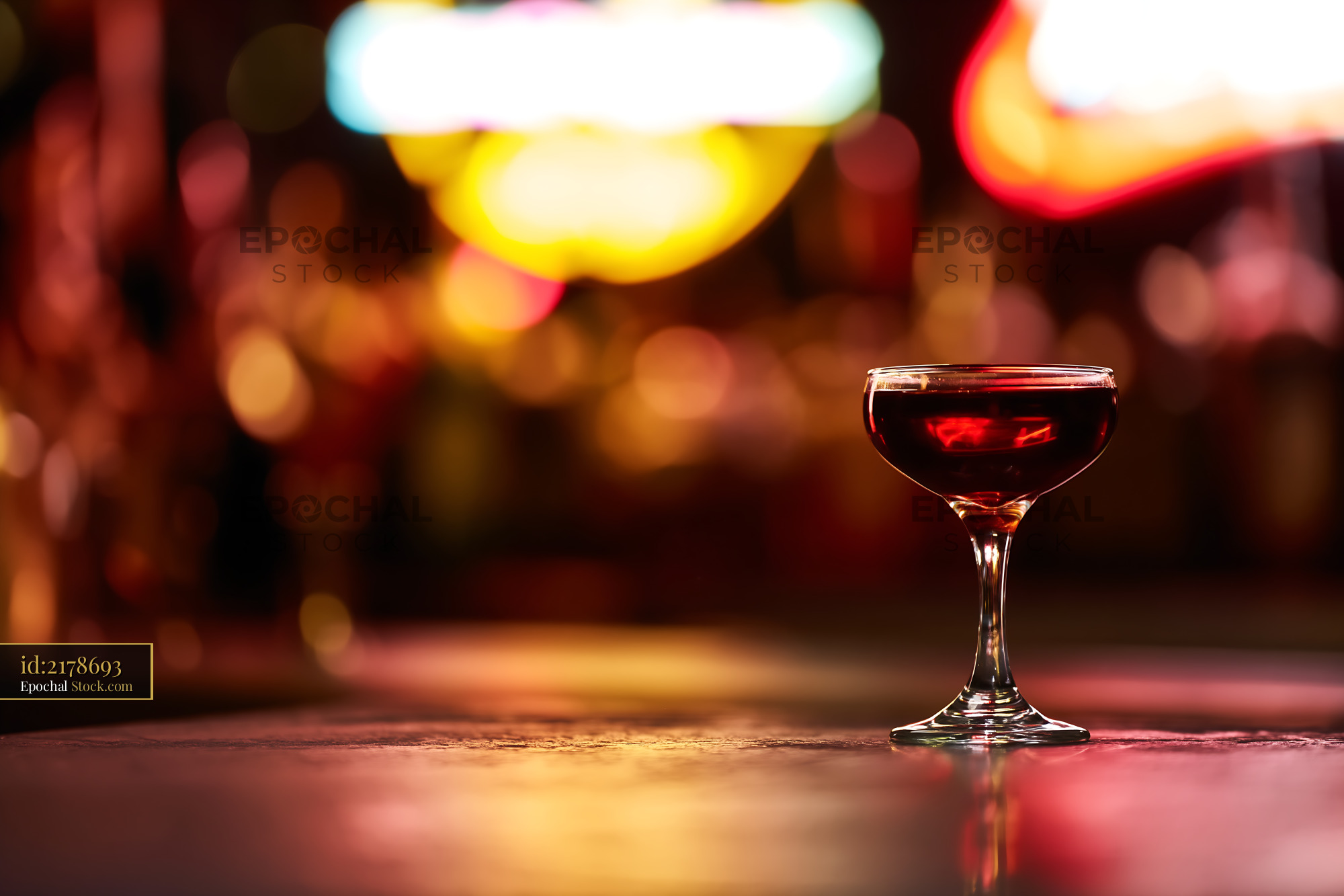 Red Cocktail Glass in Atmospheric Neon Bar - stock photo