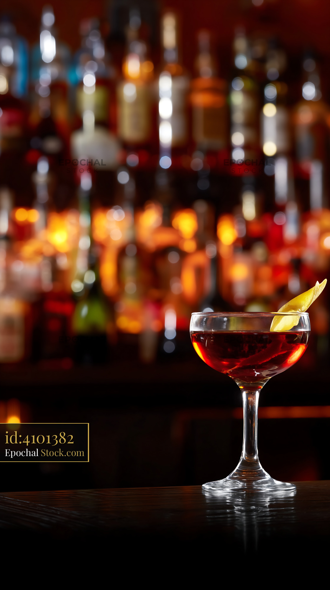 Red Cocktail with Lemon Twist at Bar - stock photo