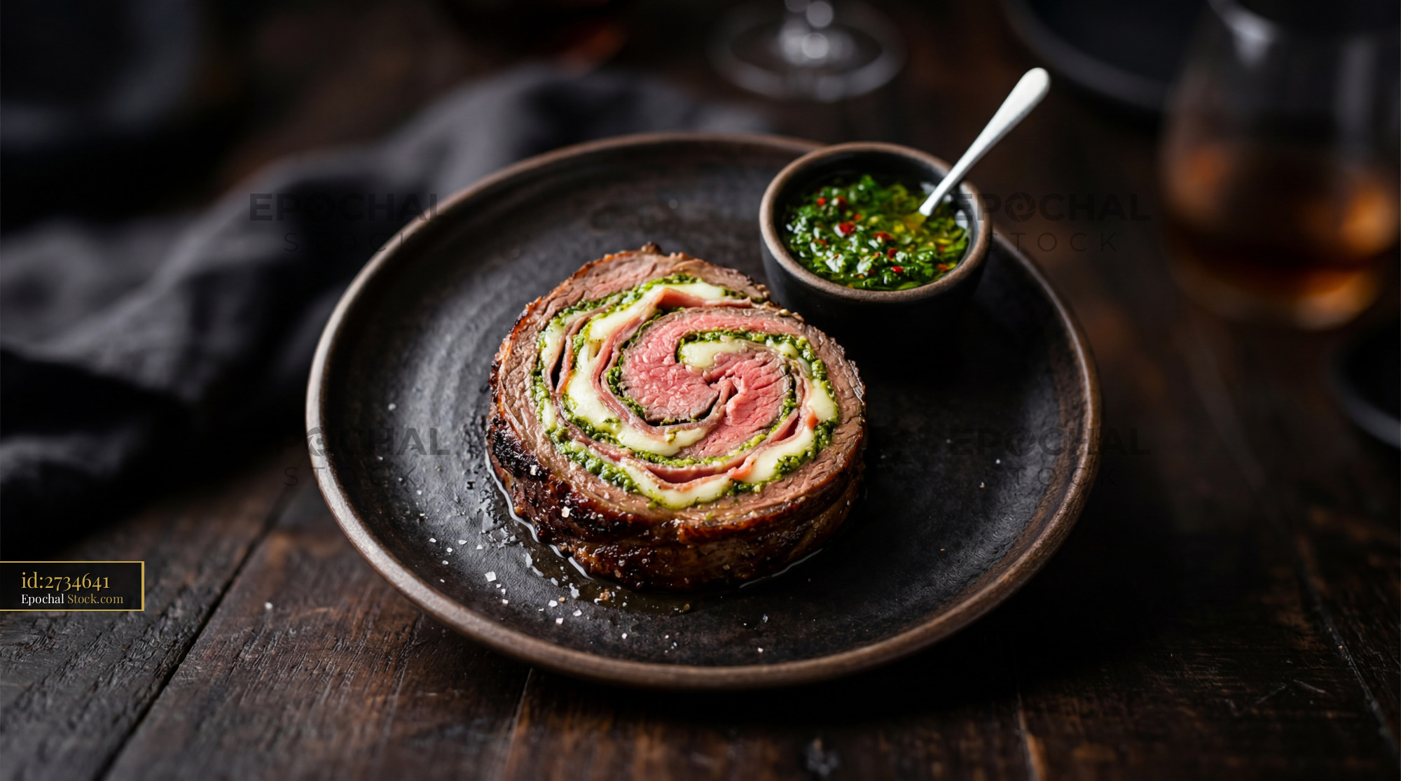 Beef Roulade with Herb Pesto on Black Plate - stock photo
