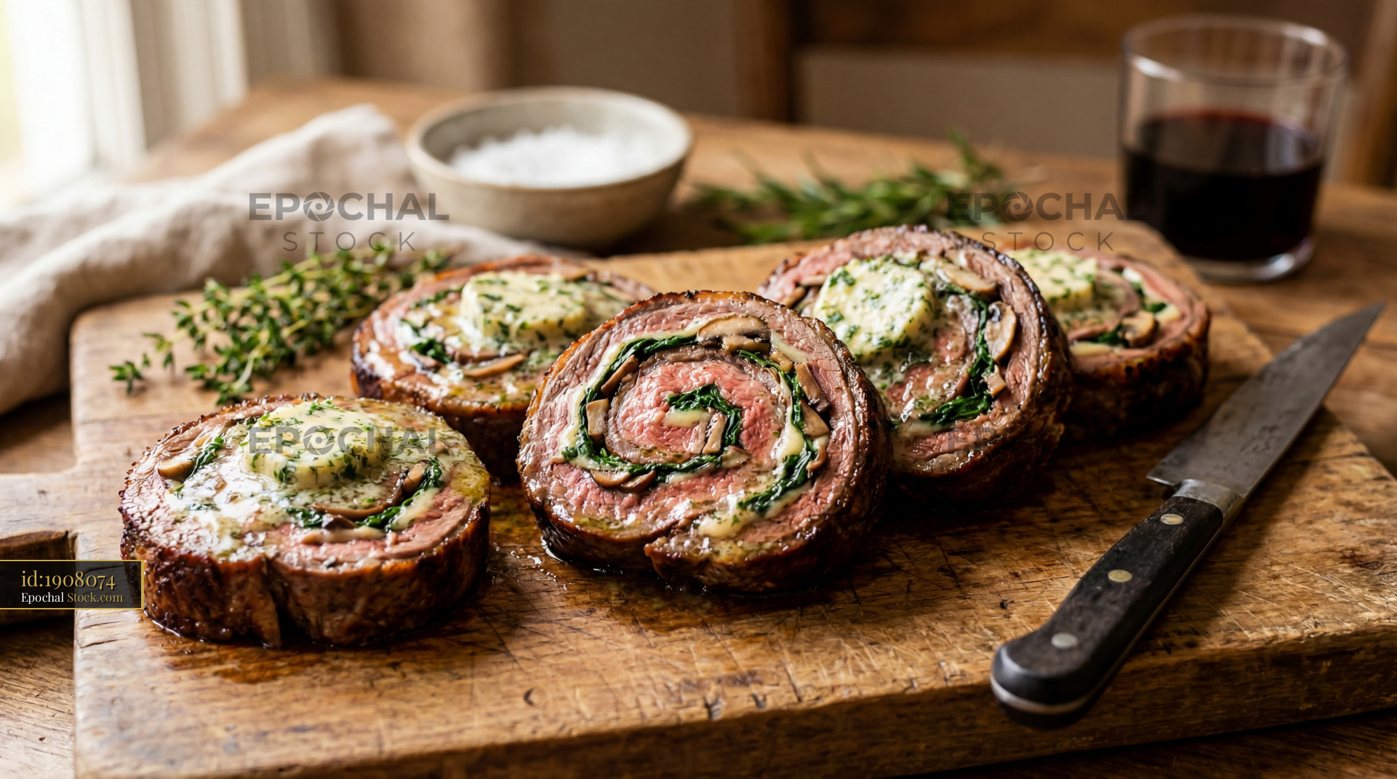 Herb-Stuffed Beef Roulade on Wooden Cutting Board - stock photo