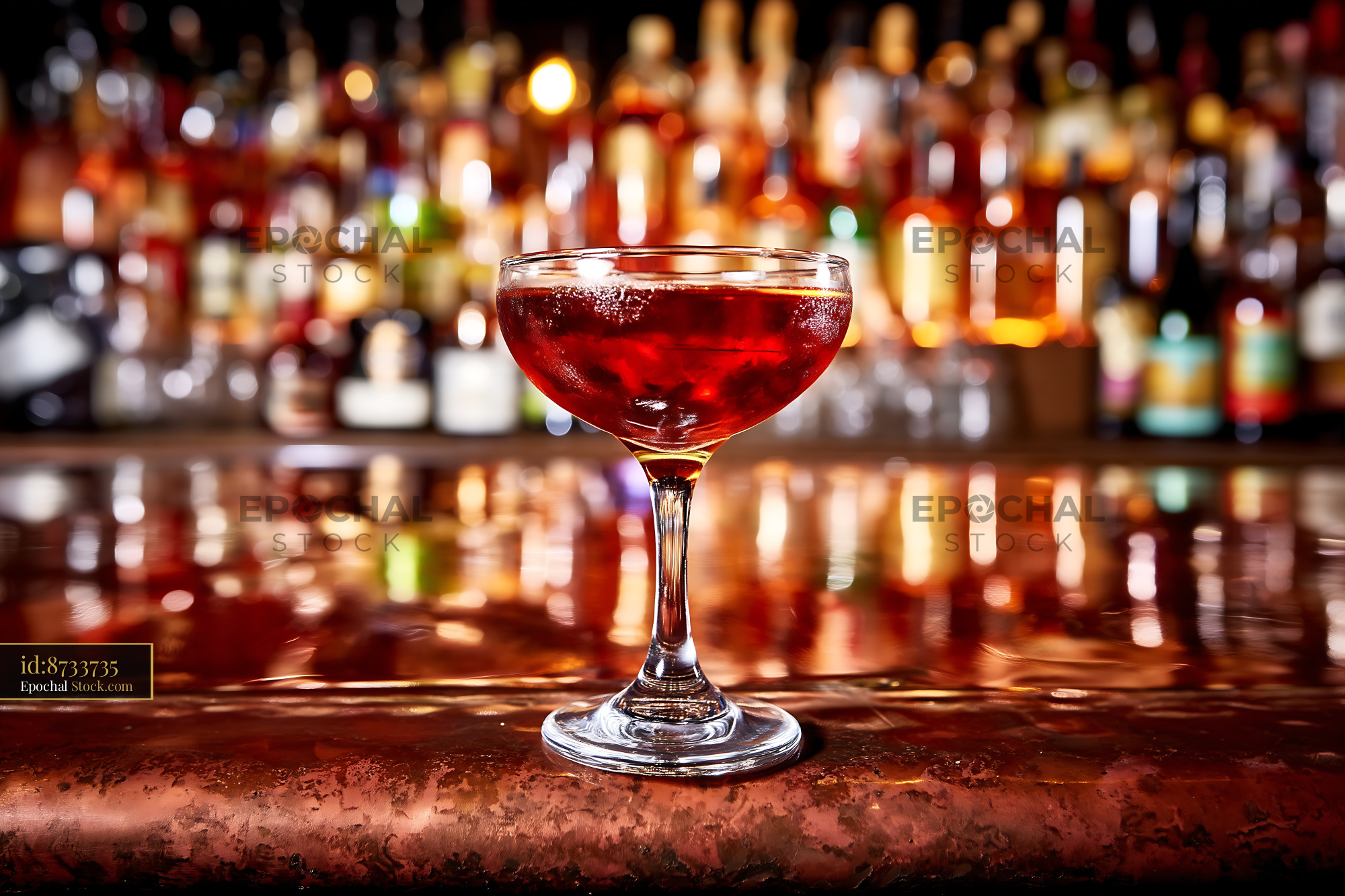 Red Cocktail in Coupe Glass Behind Bar Scene - stock photo