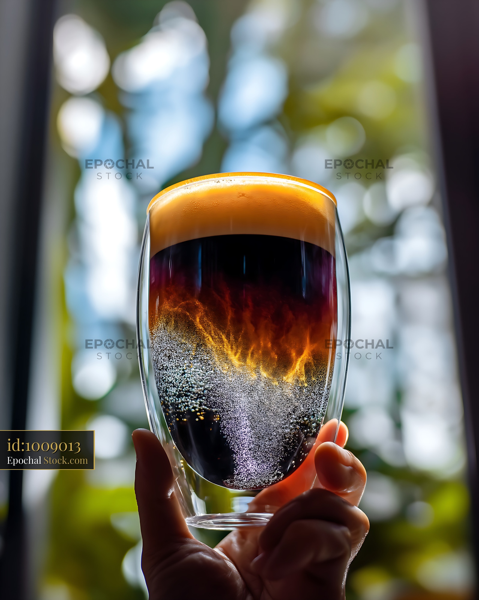 Nitro Caramel Coffee Held in Sunlit Garden - stock photo