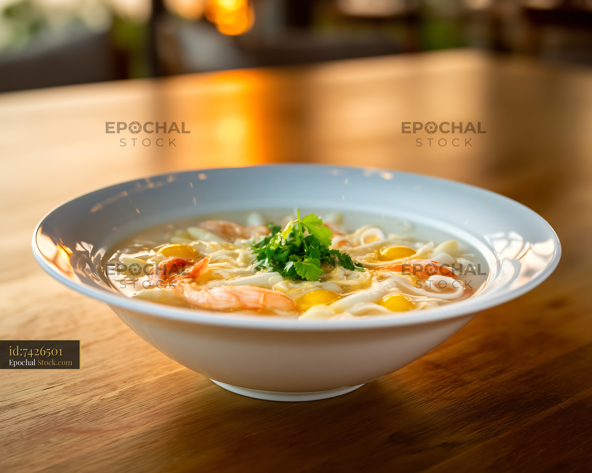 Shrimp Noodle Soup with Cilantro on Wooden Table in Golden Light - stock photo
