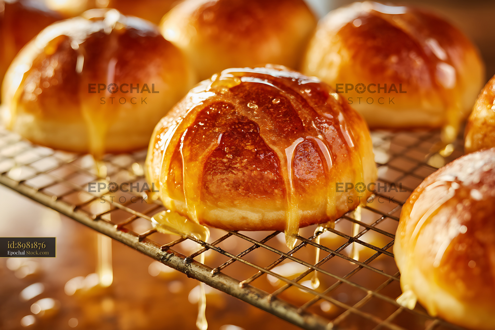 Golden Glazed Rolls Dripping on Cooling Rack - stock photo