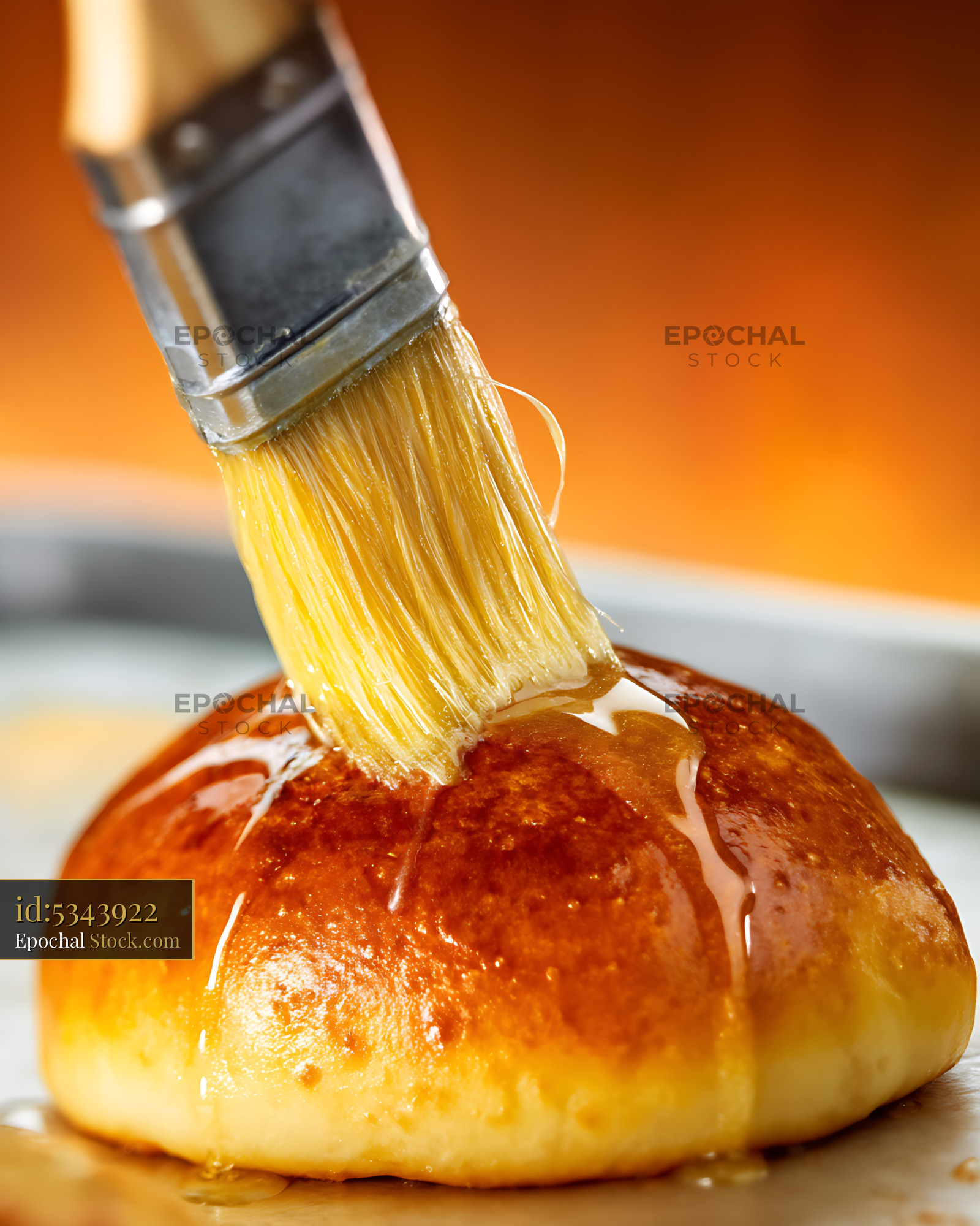 Brushing Egg Wash on Fresh Bierocks - Golden Glazed Pastry - stock photo