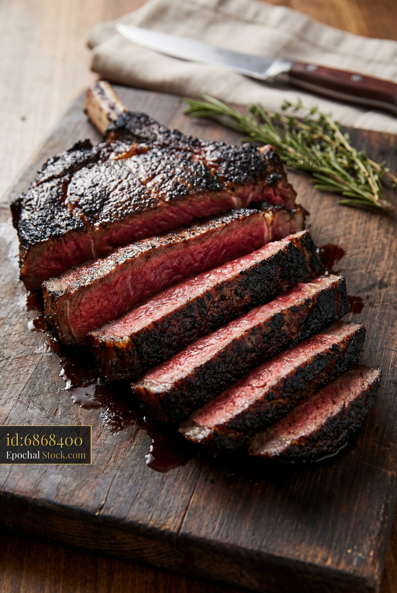 Medium-Rare Steak Sliced on Wood Cutting Board - stock photo