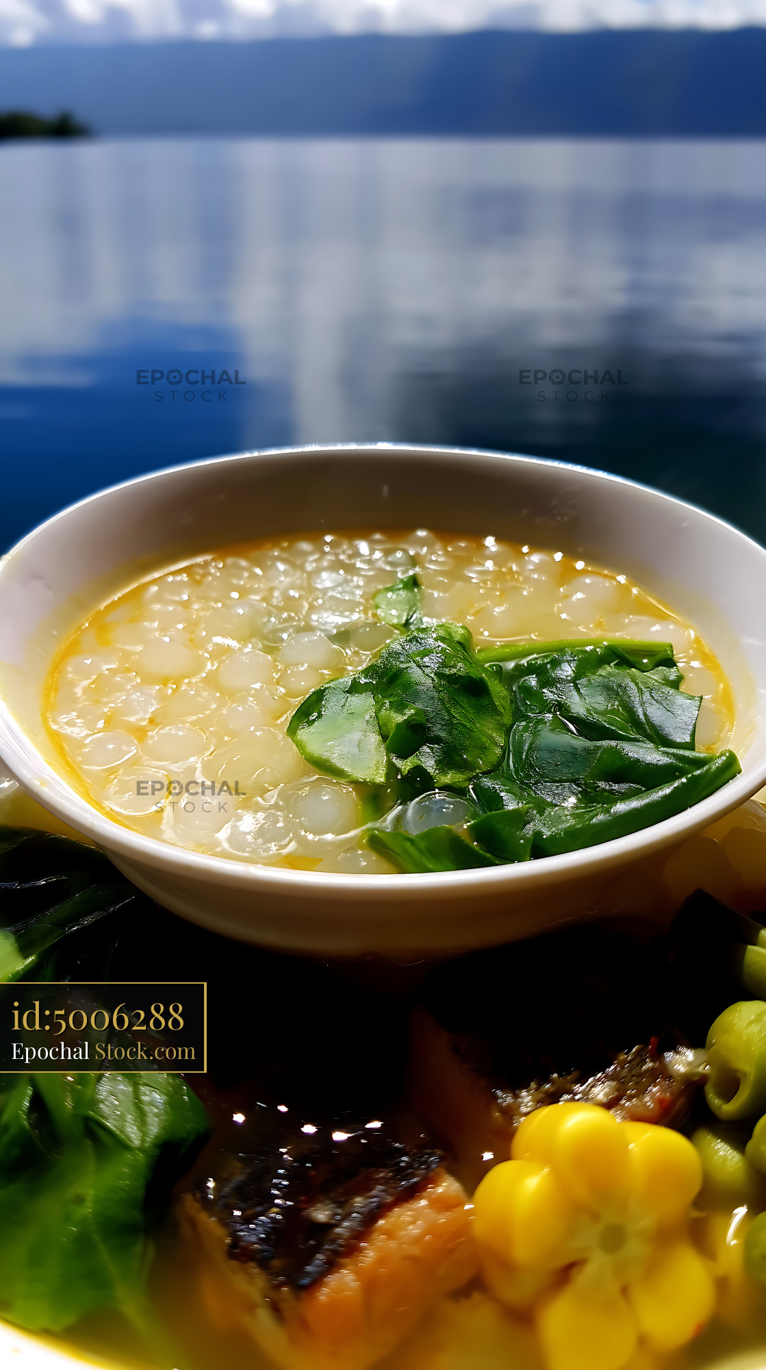 Kapurung Soup with Greens and Fish by Serene Lake - stock photo